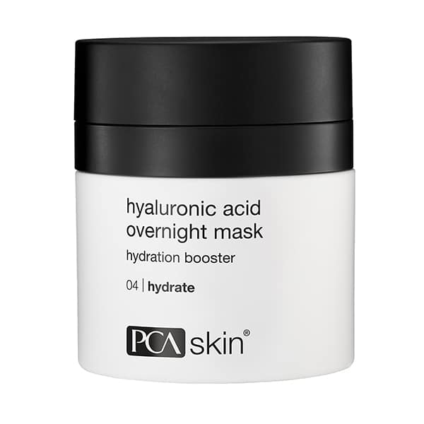A white cylindrical container with a black lid labeled "HA Overnight Mask," described as a hydration booster that enhances skin radiance, with additional text reading "04 | hydrate.