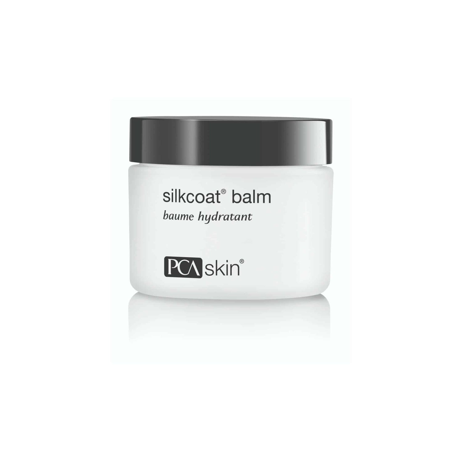 A white jar with a black lid labeled "Silkcoat Balm" from PCA Skin. The minimalist design features the brand name and product name in black text on the front of the jar, promising antioxidant protection and moisturiser benefits for ageing skin. The background is white.
