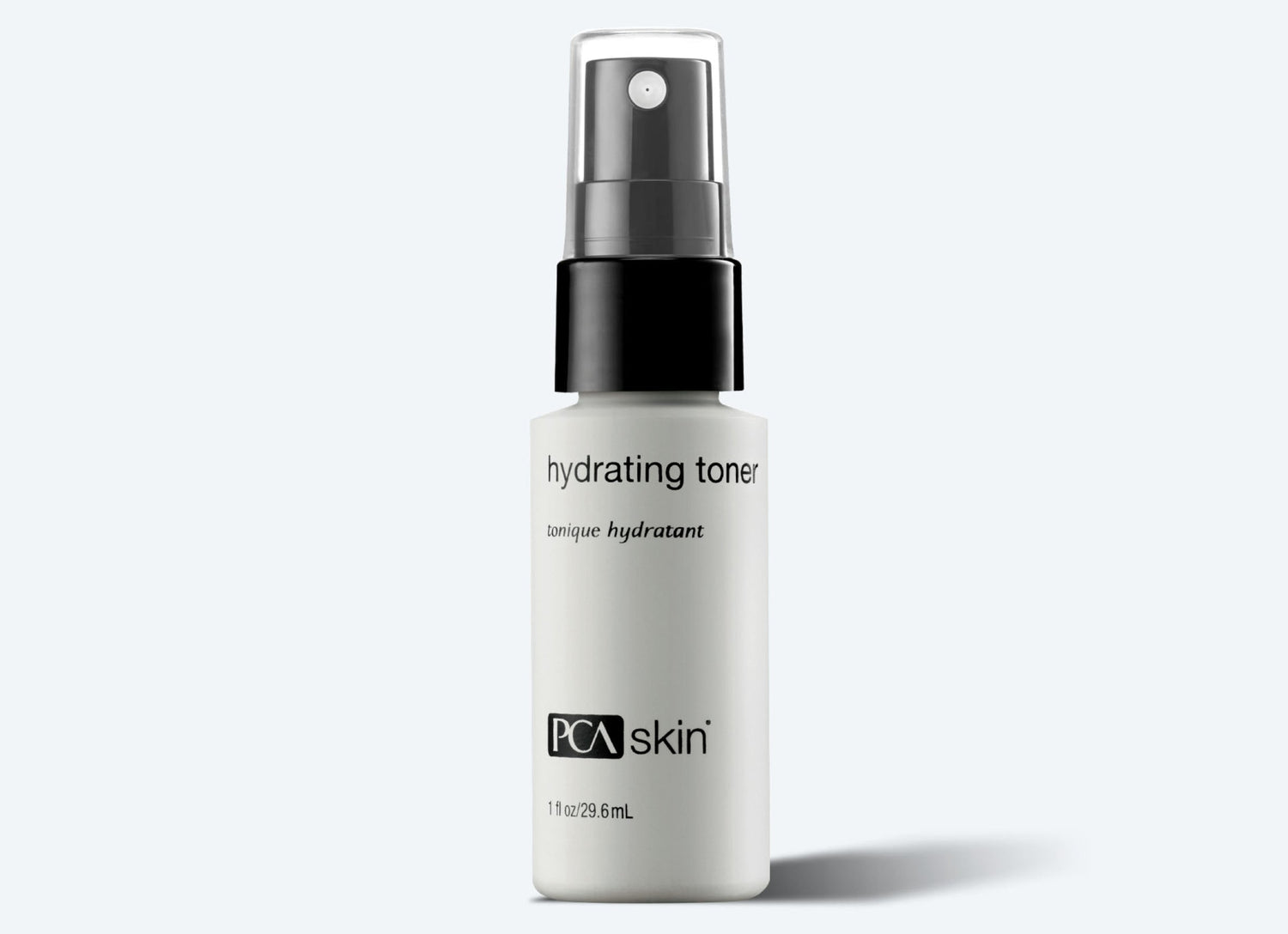 A white 30 ml bottle of Hydrating Toner Spray by PCA Skin, featuring a black spray cap, stands against a light gray background. The label highlights "hydrating toner," "PCA Skin," and its antioxidant protection benefits.
