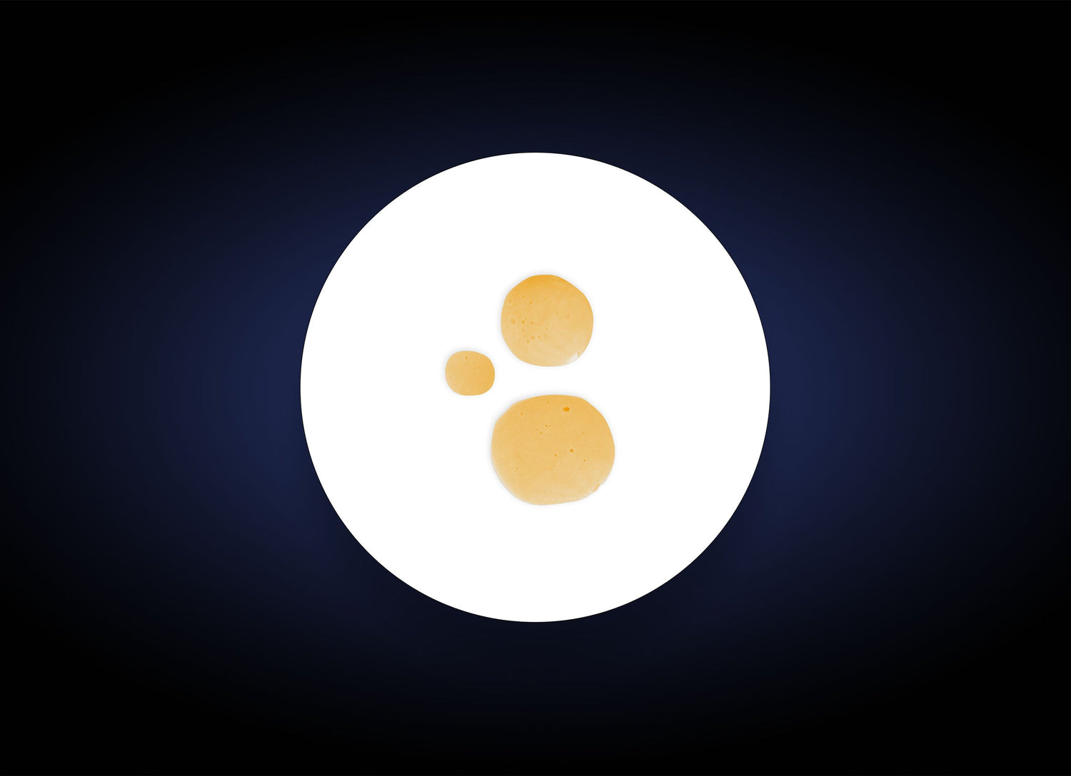 A white plate holds three small, round pancakes of varying sizes in a diagonal line on a dark blue to black gradient background, evoking the smooth, refined texture achieved with Nutrient Toner 130ml.