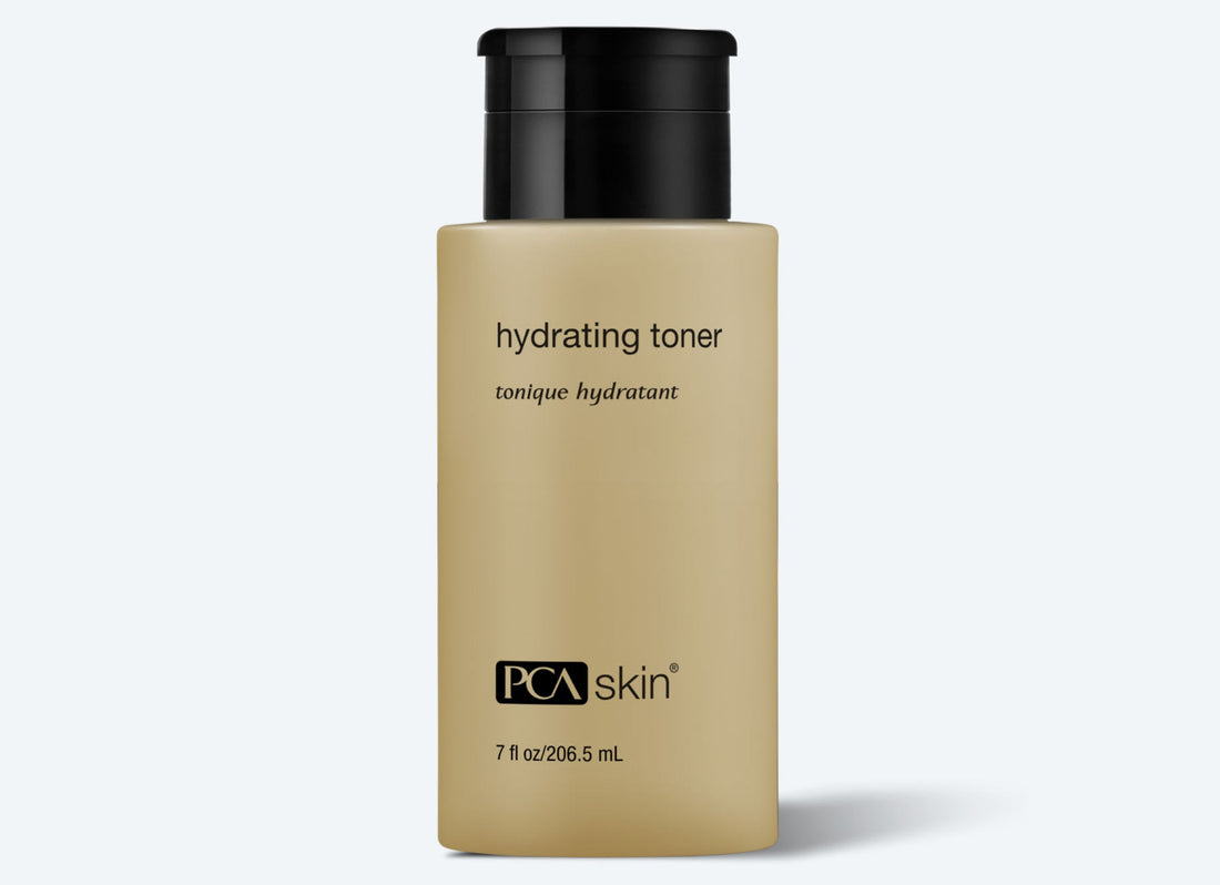 A beige bottle of Hydrating Toner 207 ml by PCA Skin with a black cap is shown. The label reads "hydrating toner" and offers daily-use antioxidant protection. Volume: 207 ml (7 fl oz).