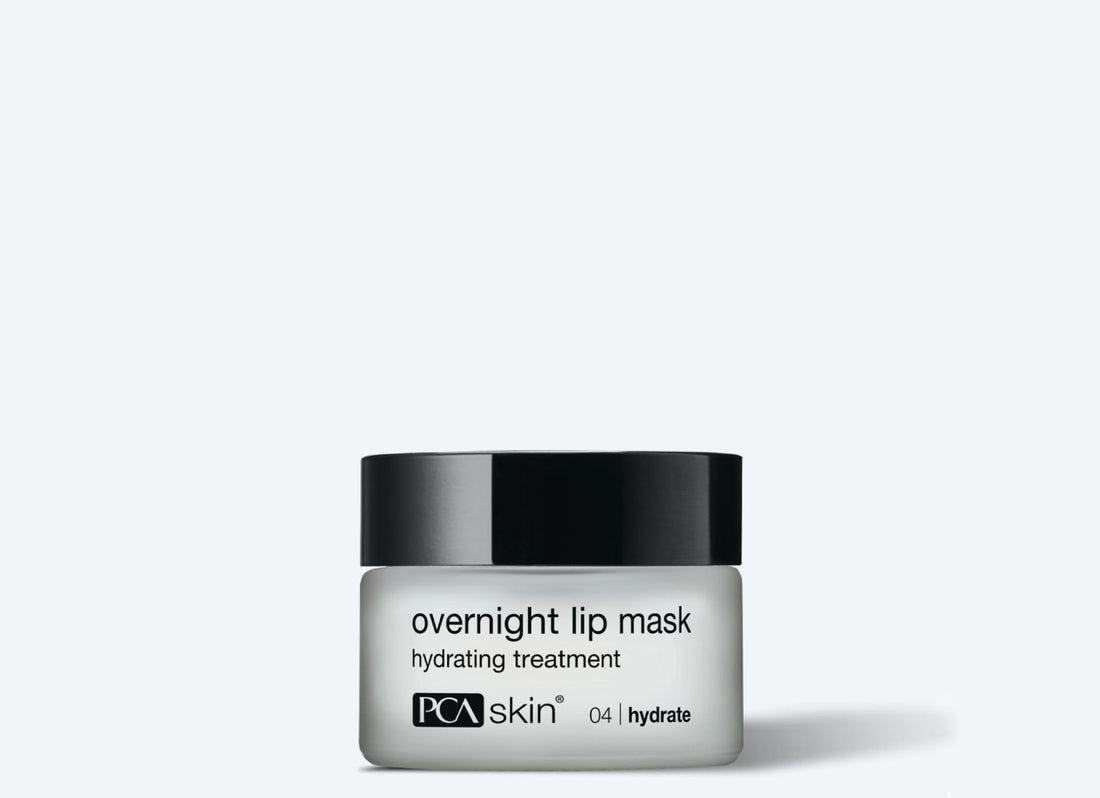 A white jar with a black lid, labeled "HA Lip Overnight Mask," from PCA Skin. The ultra-hydrating product is labeled with "04 | hydrate" at the bottom. Perfect as a nighttime lip treatment, it fights visible signs of aging. The background is light grey.