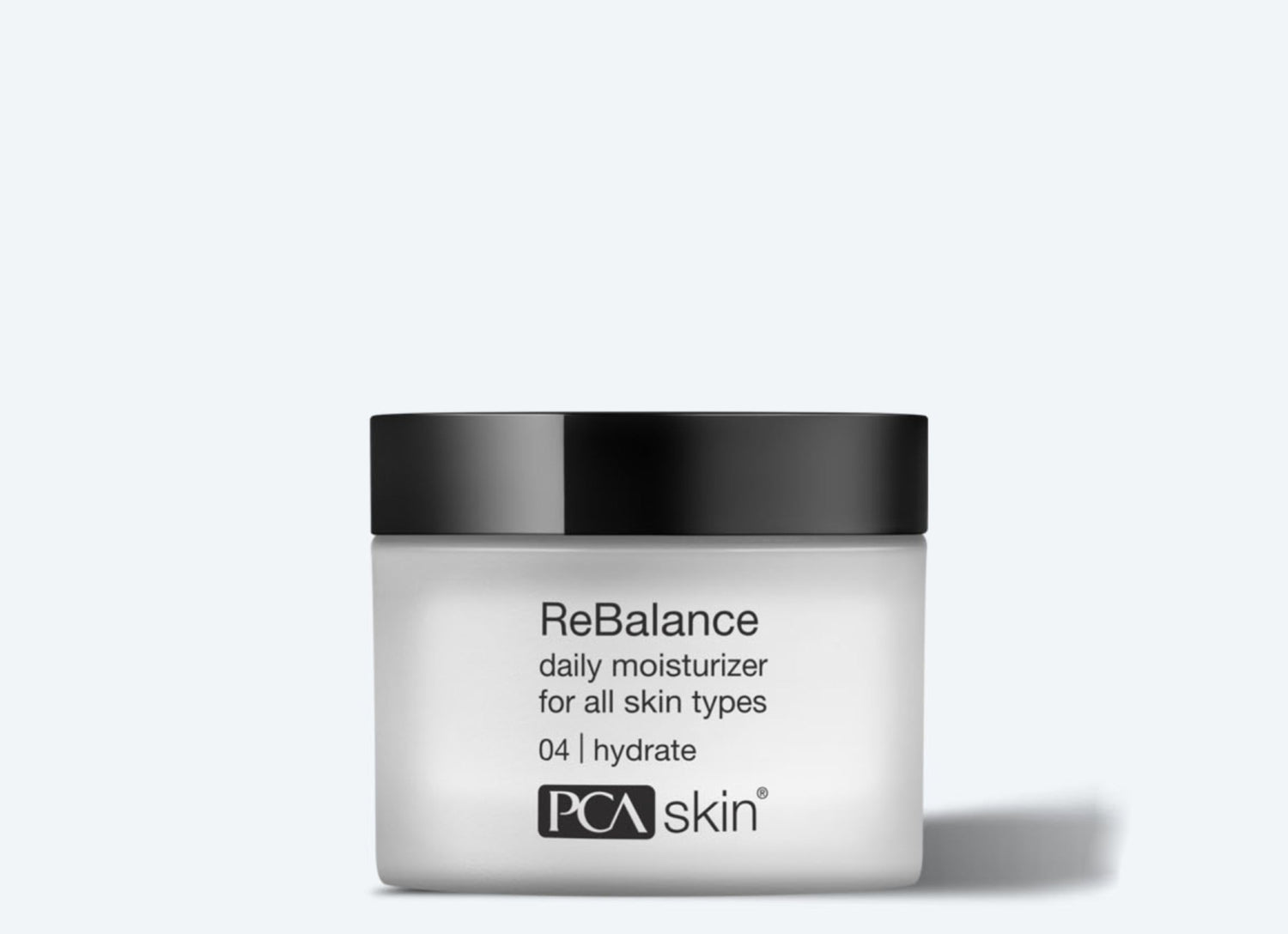 A jar of ReBalance, a daily moisturizer suitable for all skin types, including sensitive skin. The white jar with a black lid features a label that reads "ReBalance daily moisturizer for all skin types 04 | hydrate" and the "PCA Skin" logo at the bottom. The plain light gray background highlights its sleek design.