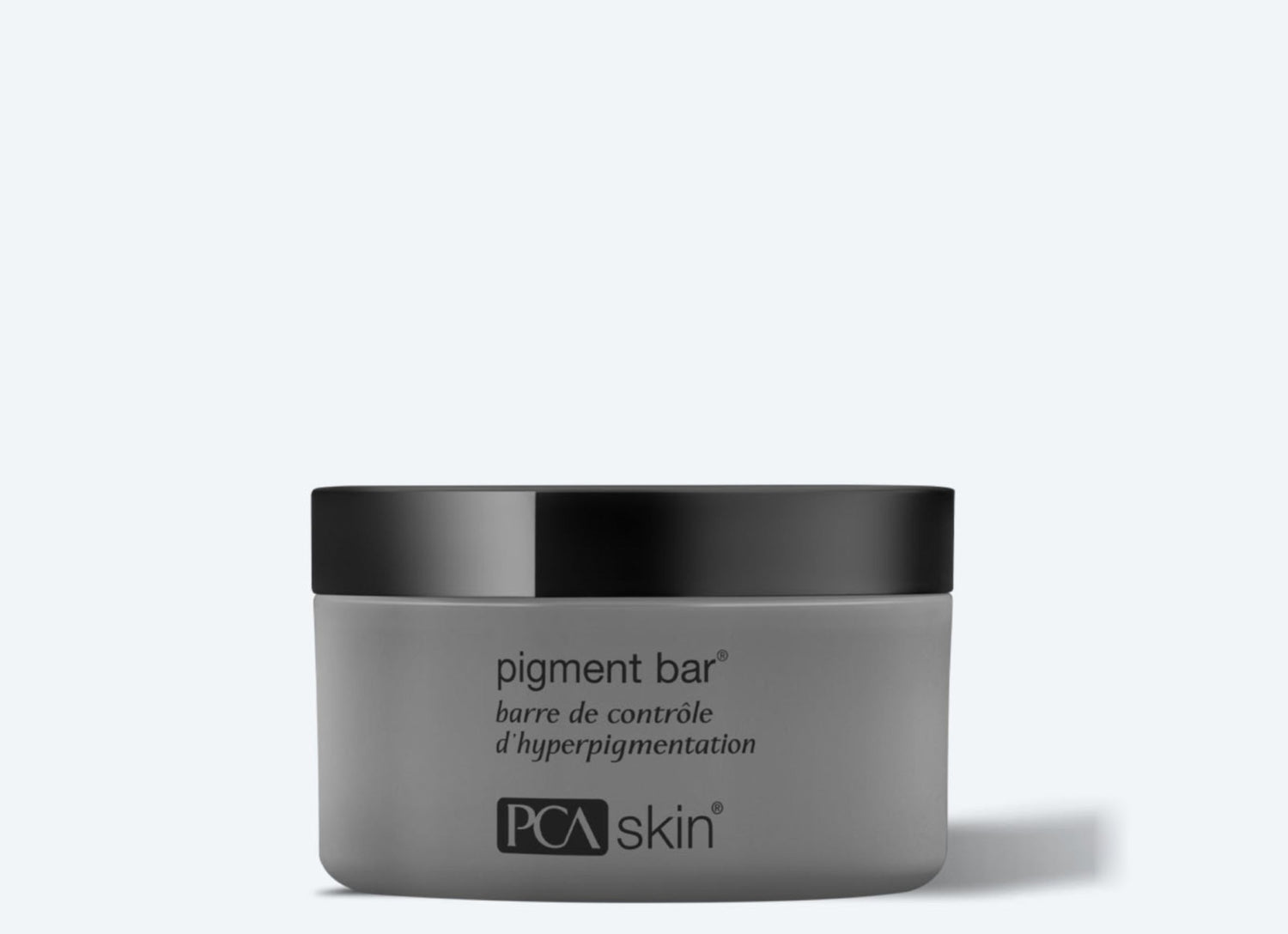 A gray jar of Pigment Bar with a black lid, designed for hyperpigmentation control and even skin tone. The text on the jar reads "pigment bar" and "barre de contrôle d’hyperpigmentation" above the "PCA skin" logo at the bottom. The background is light gray.