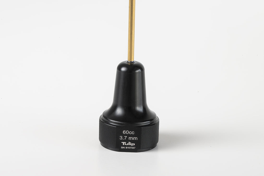 A black cylindrical medical tool labeled "Tulip" with a 60cc capacity and 3.7mm diameter, ideal for large volume fat transfer. This 60cc Monoject Toomey Hub Cannulas features a narrow gold-colored rod extending from the top and is placed against a plain white background.