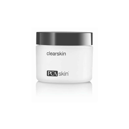 A white jar with a black lid, labeled &quot;Clearskin&quot; and &quot;PCA Skin,&quot; designed to soothe sensitive skin. The jar has a minimalist design.