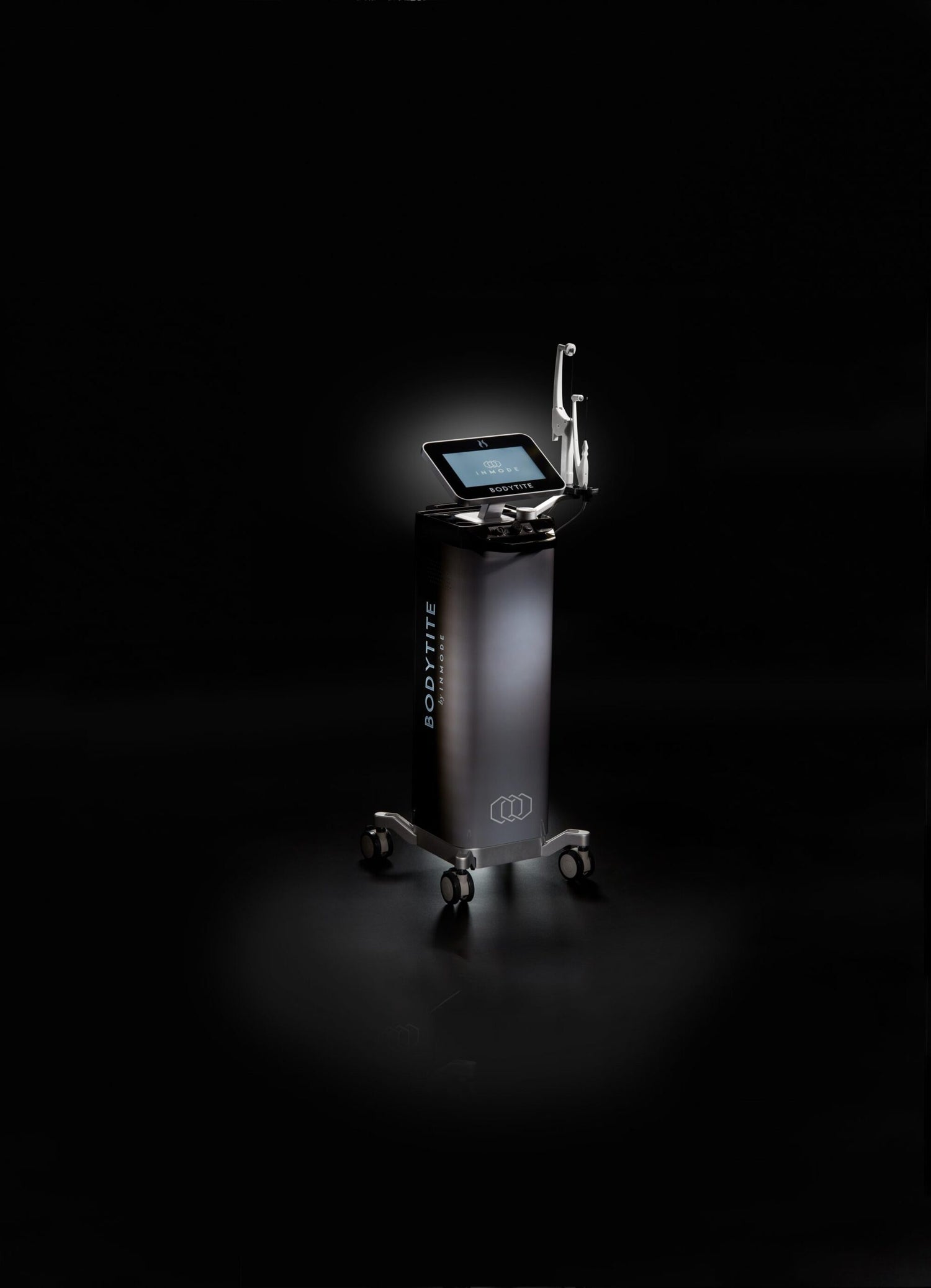 A sleek, modern medical device labeled &quot;Bodytite&quot; stands on a dark background. It features a touchscreen monitor on top and is mounted on a mobile base with four wheels for easy movement. Utilizing radiofrequency technology, this body contouring device has a minimalist design with a black and silver color scheme.