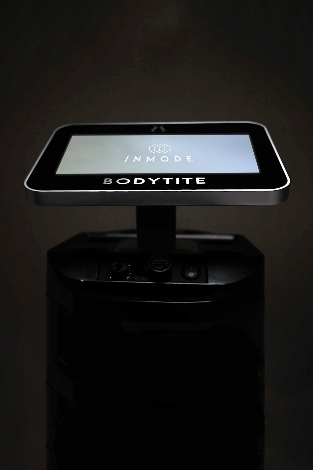 A photo showcases a sleek and modern medical device from the brand &quot;Bodytite&quot; used for body contouring, with an illuminated digital touchscreen labeled &quot;InMode&quot; on top. The rest of the device remains dark, emphasizing its advanced radiofrequency technology.