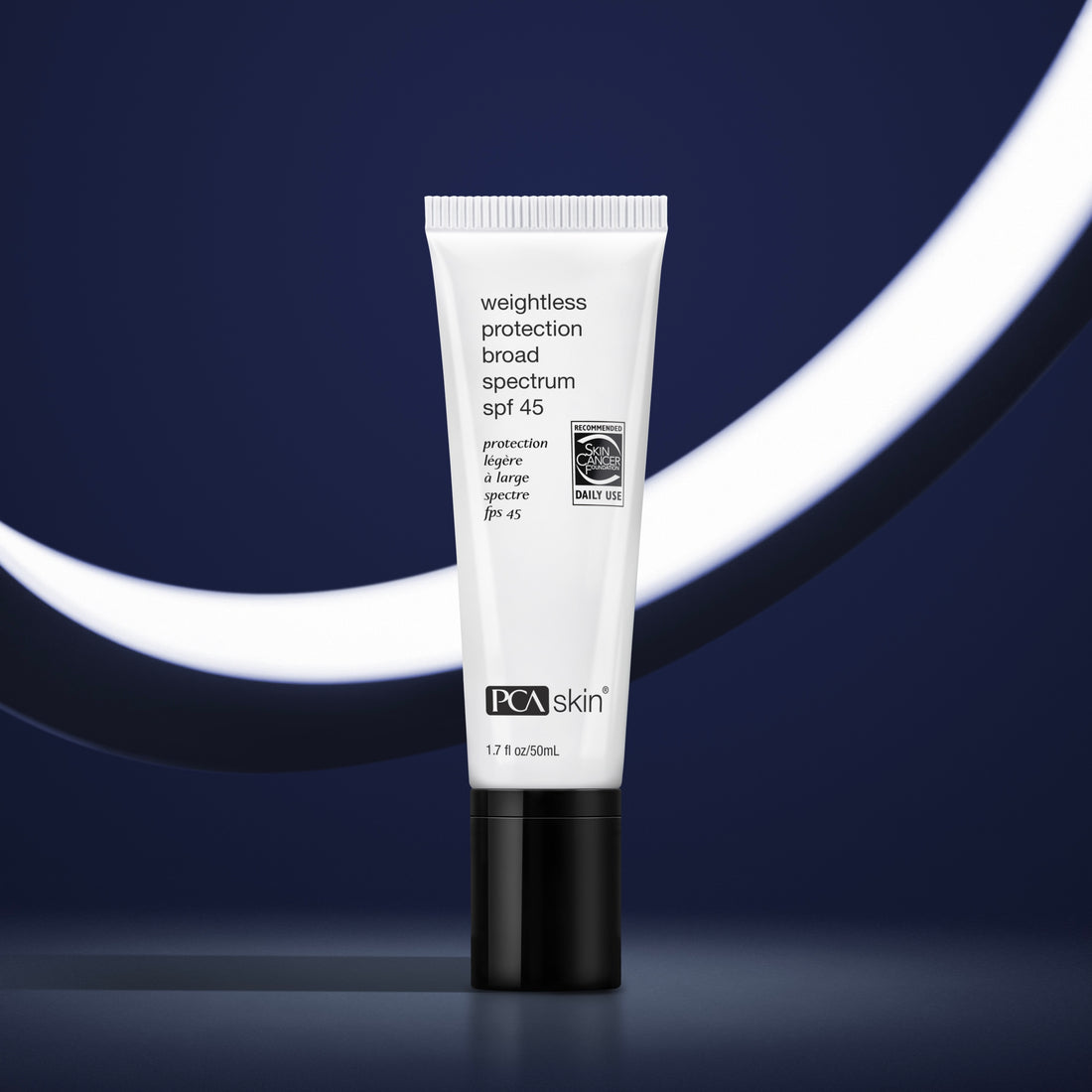 A tube of Weightless Protection BS SPF 45 stands upright against a dark blue background with a white curved light element. The tube is white with black text and detailing, holding 1.7 ounces (50 mL) of lightweight sunscreen that offers broad-spectrum protection.