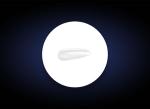 A single white sunflower seed sits centered on a bright white circle with a dark navy blue gradient background. The ReBalance, known for its moisturising and antioxidant protection qualities, is oval-shaped and slightly elongated, displayed in sharp focus against the contrasting backdrop.