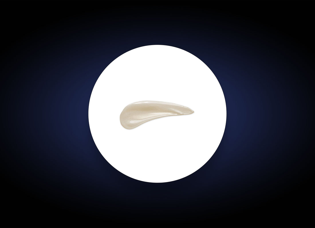 A small, smooth, white object shaped like a teardrop is centrally placed on a circular white background. The outer background is dark blue, gradually getting lighter towards the center. This composition evokes the sensation of using Hydrating Mask that enhances skin moisture retention with soothing ingredients.