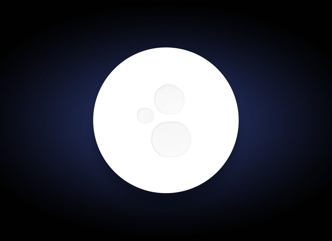 A bright white circle with three smaller translucent circles inside, set against a dark blue to black gradient, evokes the instant hydration and antioxidant-rich benefits of Daily Defense Mist Antioxidant Spray 59 ml.