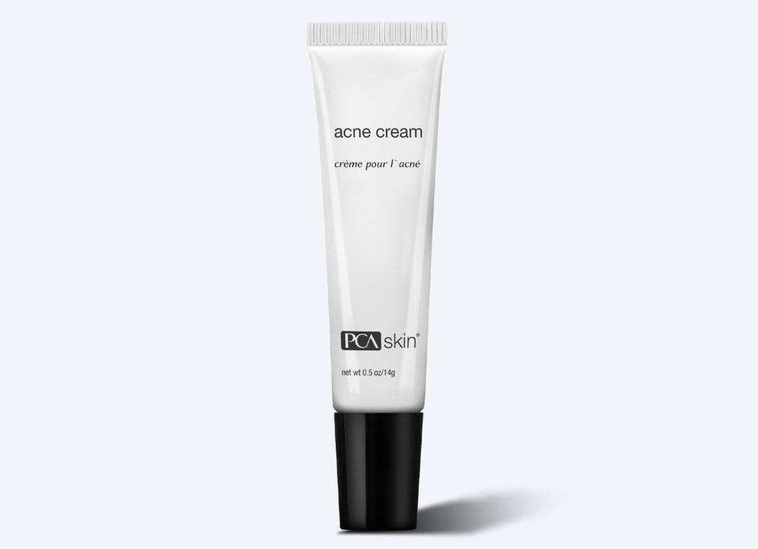 A white tube of Acne Cream 14 g with a black cap. The label reads &quot;acne cream&quot; and &quot;crème pour l&