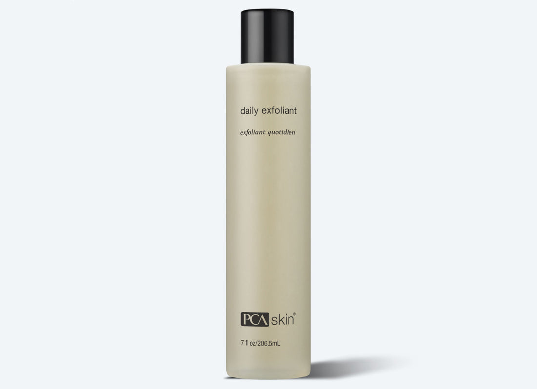 A beige cylindrical bottle with a black cap, labeled &quot;Daily Exfoliant&quot; in small black letters and &quot;PCA skin&quot; at the bottom. The minimalist design highlights its 7 fl oz (206.5 ml) of product containing biodegradable exfoliants that gently cleanse and renew your skin.