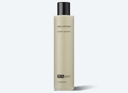 A beige cylindrical bottle with a black cap, labeled &quot;Daily Exfoliant&quot; in small black letters and &quot;PCA skin&quot; at the bottom. The minimalist design highlights its 7 fl oz (206.5 ml) of product containing biodegradable exfoliants that gently cleanse and renew your skin.