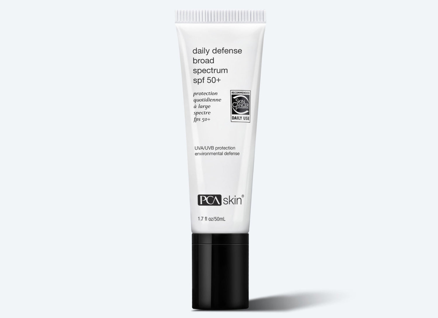 A white tube of Daily Defense SPF 50+ with black text on the label and a black cap, displayed against a light gray background. The tube indicates it offers UVA/UVB protection and environmental defense, with environmental protection ingredients in 1.7 fl oz (50 mL).