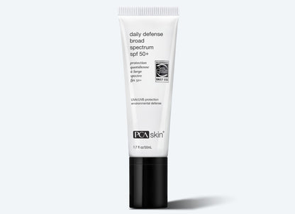 A white tube of Daily Defense SPF 50+ with black text on the label and a black cap, displayed against a light gray background. The tube indicates it offers UVA/UVB protection and environmental defense, with environmental protection ingredients in 1.7 fl oz (50 mL).