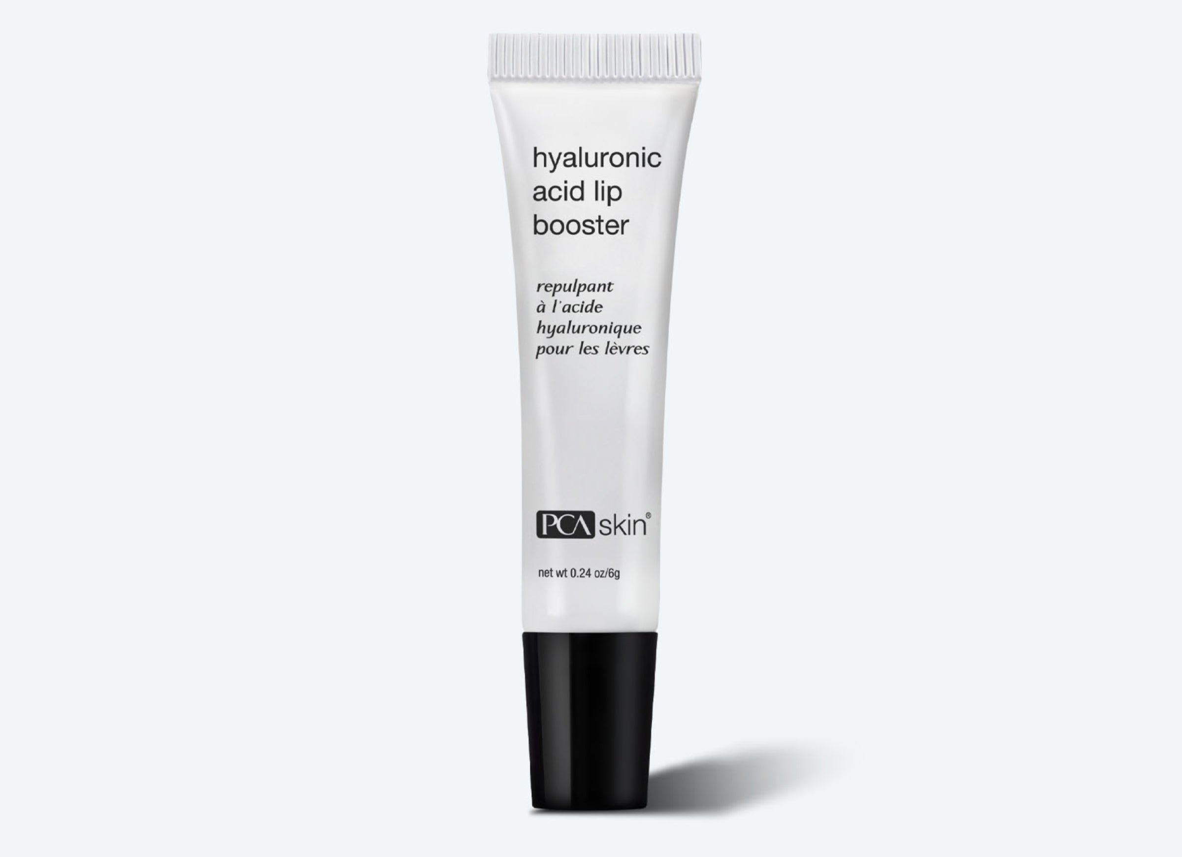 A white tube of Hyaluronic Acid Lip Booster is shown against a white background. The tube features black text and a black cap. The product is described in both English and French, highlighting its role in enhancing collagen production. The net weight of the product is 0.24 oz (7 g).