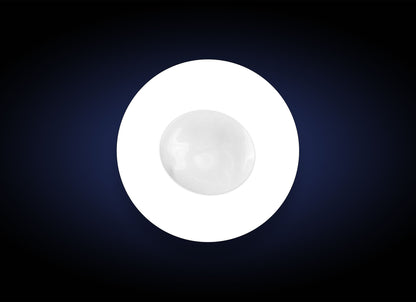 A single white round object, resembling a marble or a smooth stone, placed in the center of a white circle against a dark, gradient background. The circle and background create a striking contrast, emphasizing the simplicity and symmetry of the composition, akin to how Hyaluronic Acid Lip Booster highlights natural beauty.