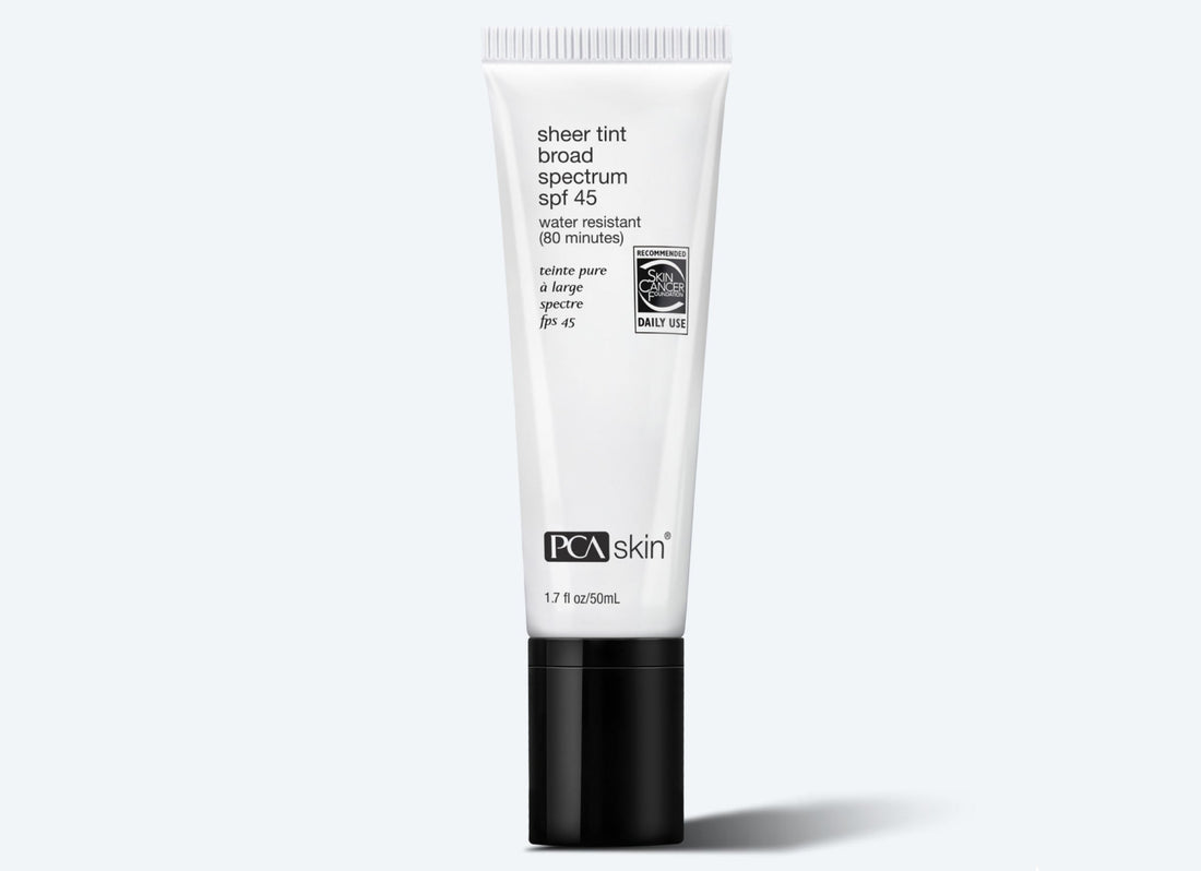 A white tube of Sheer Tint Broad Spectrum SPF 45 offers broad spectrum protection and water resistance for 80 minutes, labeled for daily use. The minimalist design features a black cap and contains 1.7 oz (50 ml) of tinted sunscreen, detailing all the product&