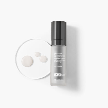 A bottle of Pro-Max Age Renewal serum, labeled as an advanced anti-aging serum with Micro Growth Factor Technology, is placed next to a petri dish containing three drops of the serum. The gray bottle features black and white text and has a black cap.