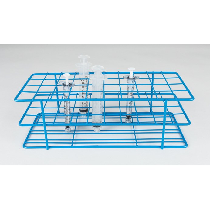 A blue wire Syringe Rack 1CC, 3CC, 5CC, 10CC, Autoclavable holds three vertical glass syringes with measured markings. Each syringe is partially filled with a clear liquid and features a white piston. The rack and syringes are set against a plain, light grey background.