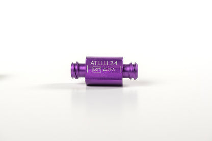 A small, cylindrical, purple metal component is centered against a white background. It has two narrow extensions on either end and is labeled &quot;ATLLLL2.4&quot; with &quot;LOT 2351-A&quot; below it. Designed for reusable transfers, it&